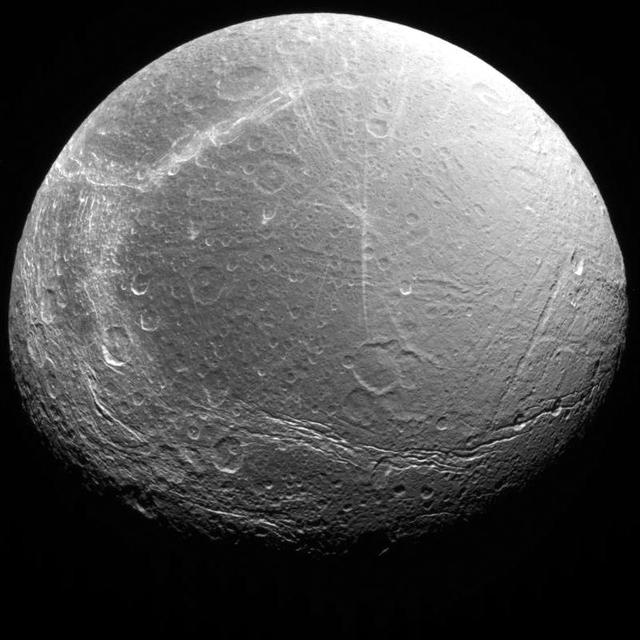 A grey moon with numerous craters and canyons visible, photographed by Voyager 2. (Source: NASA/JPL-Caltech)