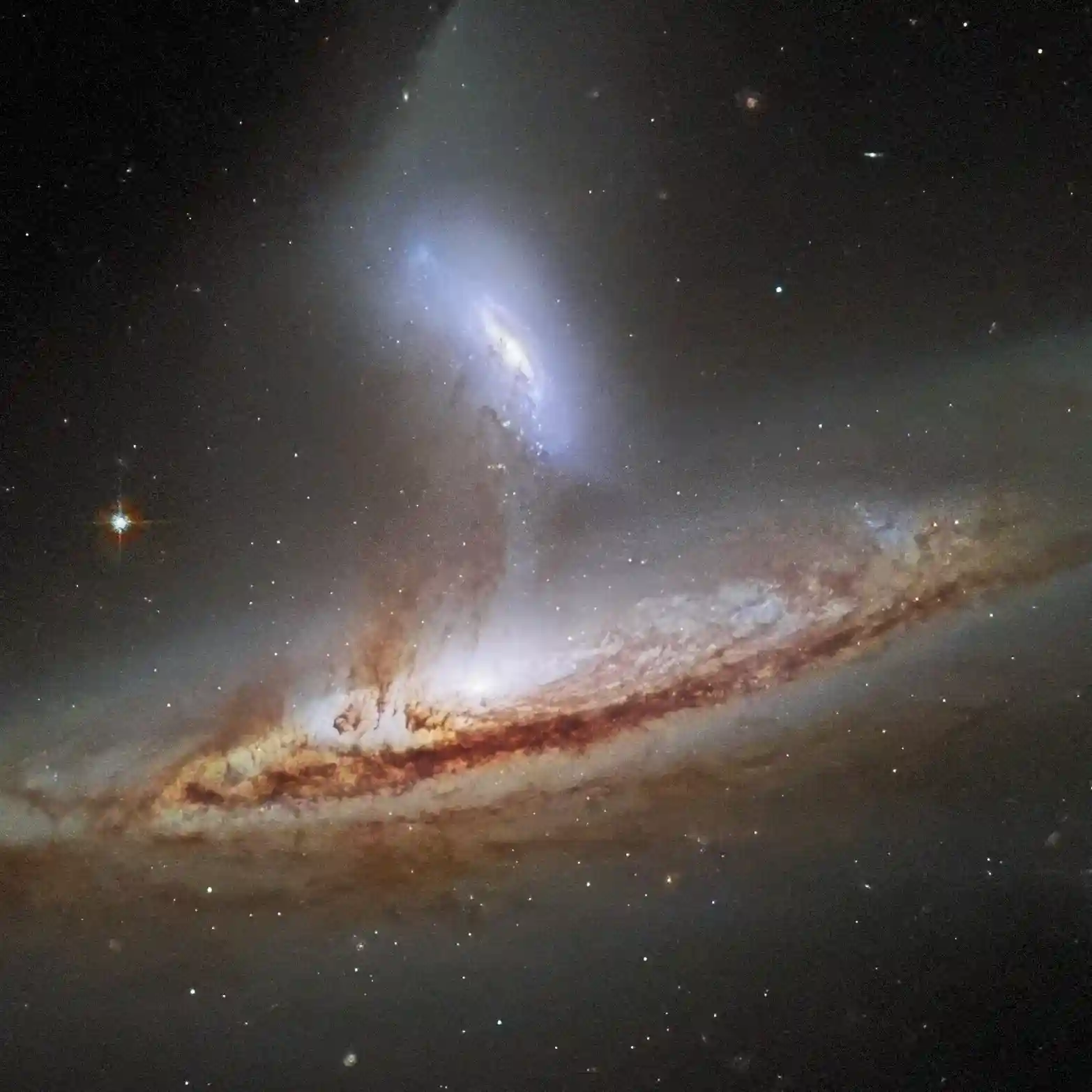 Small circular image of two galaxies whose gravitational fields are interacting on eachother. (Source: NASA)